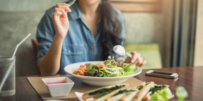 Closeup de uma mulher comendo salada saudável. Mulher sorridente bonita comendo salada saudável.