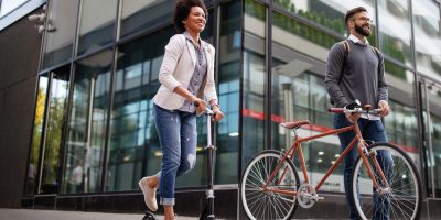 Mulher e homem andando de bike e patinete