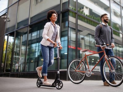 Mulher e homem andando de bike e patinete