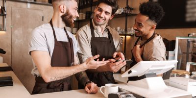 Homens de avental, sorrindo enquanto trabalham