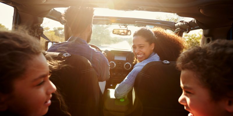 Família feliz, no carro, indo viajar